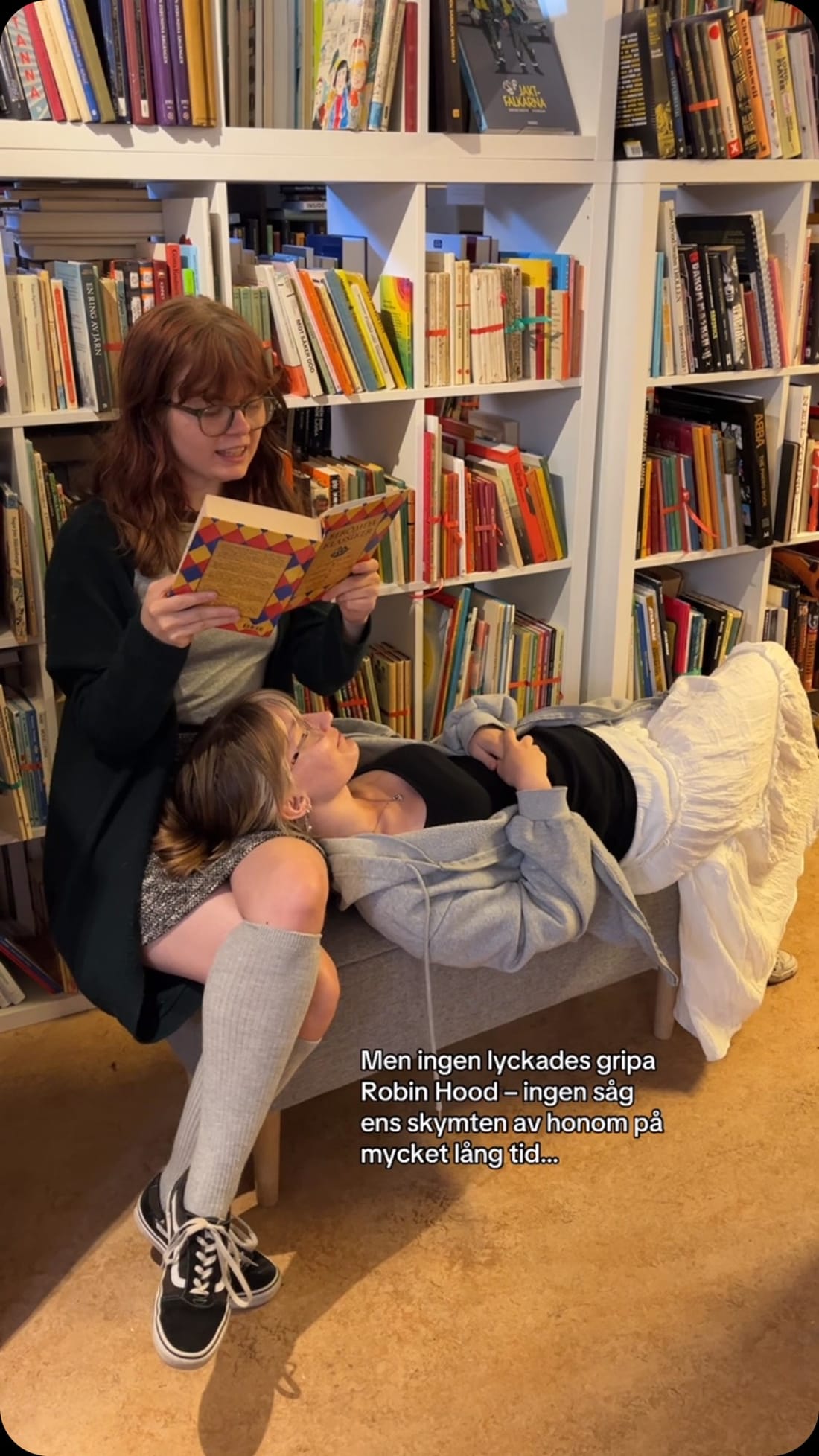 Två besökare läser bland hyllorna